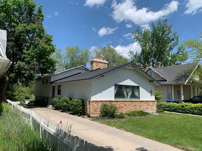 Completed residential roof replacement on a white two-story home in Davis County, Utah